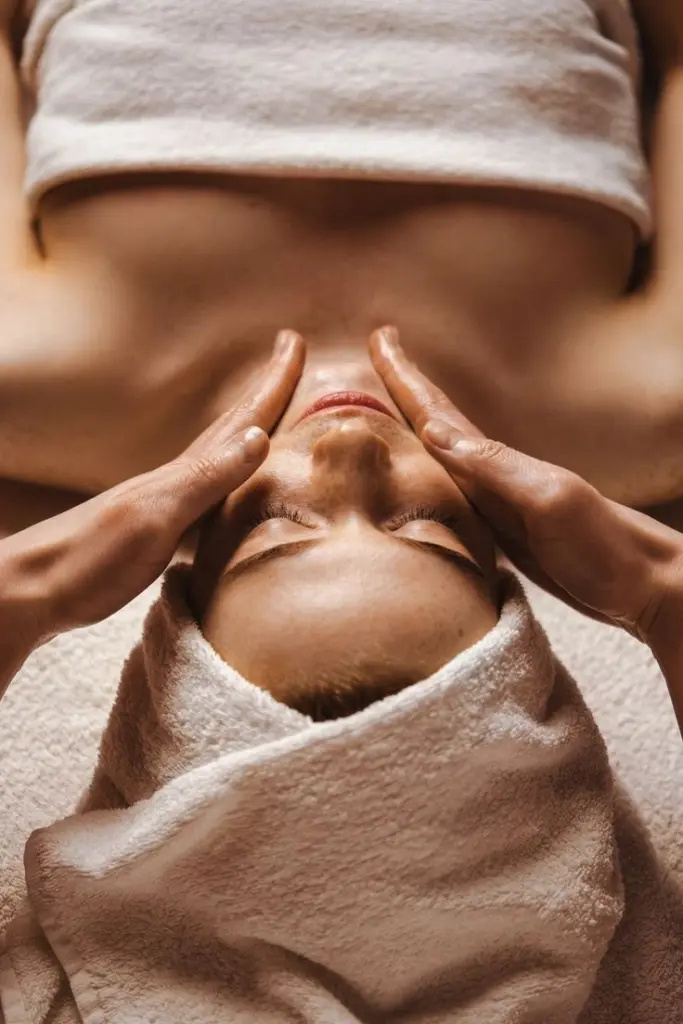 Ontspannende gezichtsmassage met handen op het gelaat